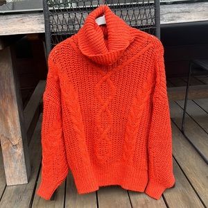 Bright orange/red knitted sweater with loose turtleneck